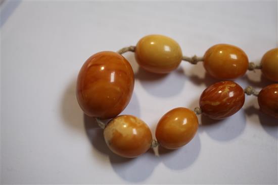 A single strand amber bead necklace and similar bracelet, gross weight 65 grams.